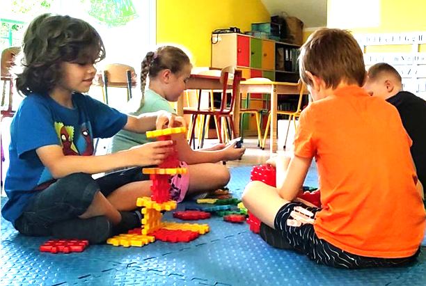 Dzieci w przedszkolu Sezamkowe bawią się klockami i rozwijają umiejętności konstrukcyjne w sali zajęć.