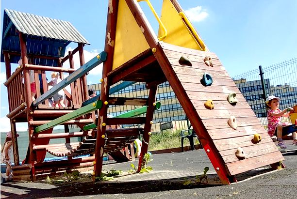 Plac zabaw przedszkola Sezamkowe z drewnianymi urządzeniami do wspinania i aktywności ruchowej dzieci.